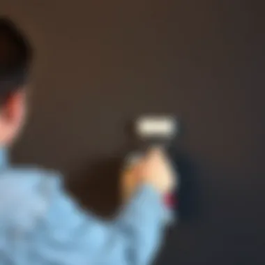 Person applying primer on a dark wall